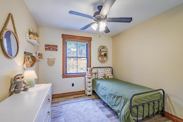 bedroom with baseboards, ceiling fan, and wood finished floors
