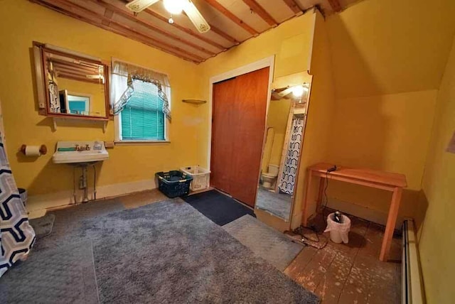 interior space featuring baseboards, a baseboard heating unit, and a ceiling fan