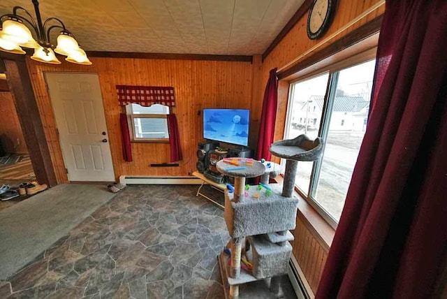 interior space with a baseboard heating unit, wood walls, stone finish flooring, and a chandelier