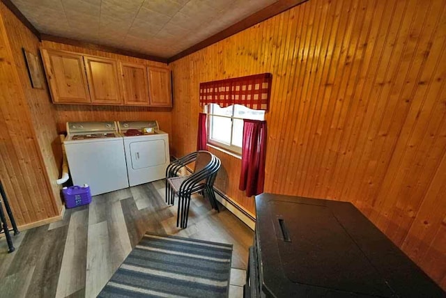 laundry area featuring separate washer and dryer, wood finished floors, wood walls, and cabinet space