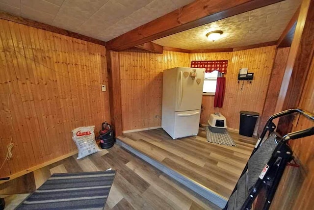 exercise area featuring baseboards, wood finished floors, and wooden walls