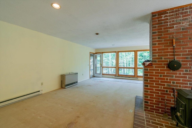 unfurnished living room with a baseboard heating unit, a textured ceiling, carpet floors, a wood stove, and a baseboard radiator