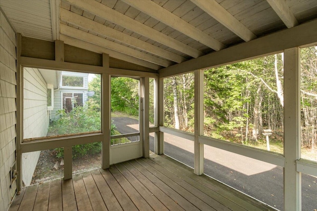 unfurnished sunroom featuring beam ceiling