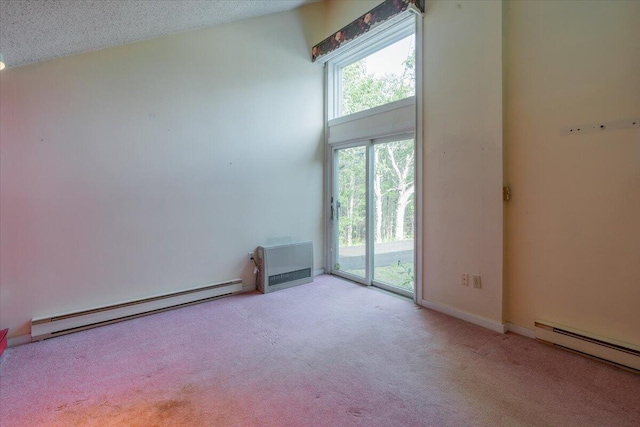 spare room with a baseboard radiator, a high ceiling, and carpet