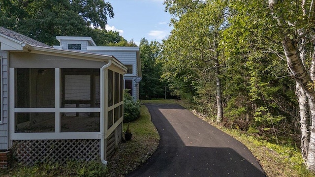 view of side of property with a sunroom and driveway