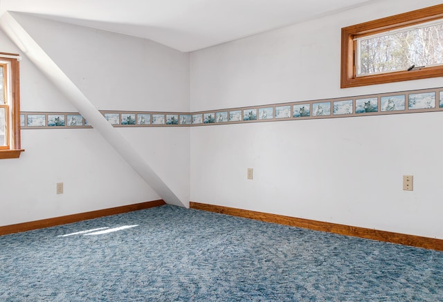 carpeted empty room featuring baseboards