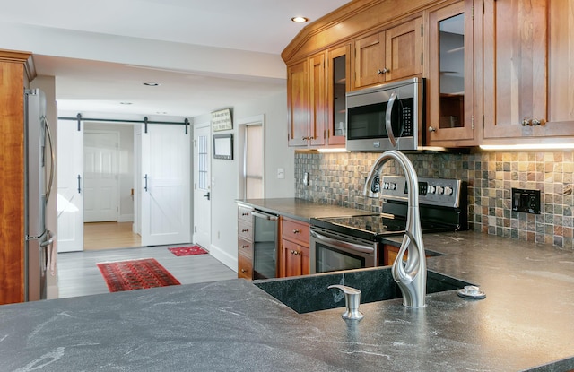 kitchen with recessed lighting, tasteful backsplash, brown cabinetry, and stainless steel appliances