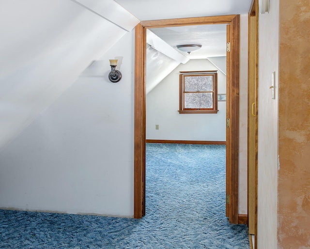 corridor with vaulted ceiling and carpet