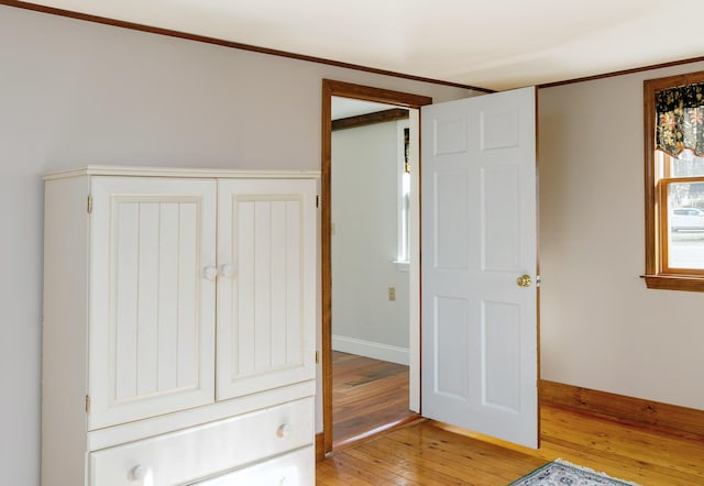 unfurnished bedroom featuring baseboards, light wood-style floors, and a closet