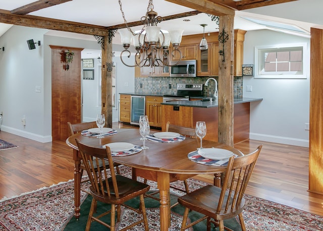 dining space featuring baseboards, wine cooler, and light wood-style flooring