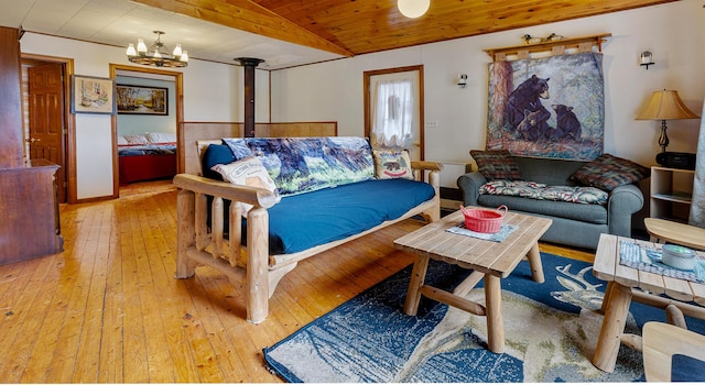119 W Conroy Lake Rd, Monticello, ME 04760 - living area with vaulted ceiling, a chandelier, a wood stove, light wood-style floors, and wooden ceiling