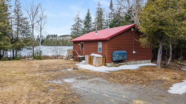 119 W Conroy Lake Rd, Monticello, ME 04760 - view of side of home with metal roof, heating fuel, and faux log siding