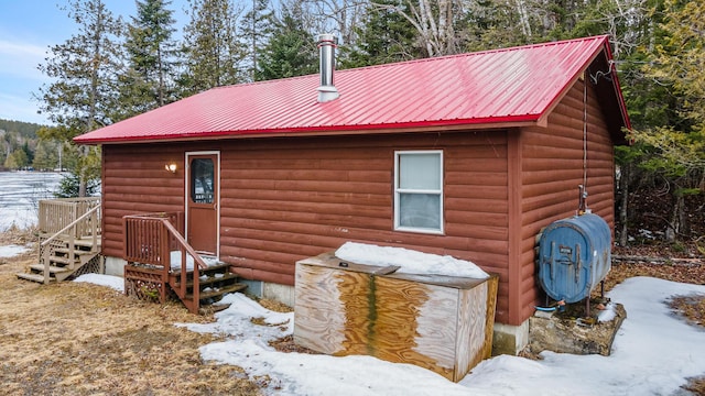 119 W Conroy Lake Rd, Monticello, ME 04760 - view of snow covered exterior with heating fuel, metal roof, and faux log siding