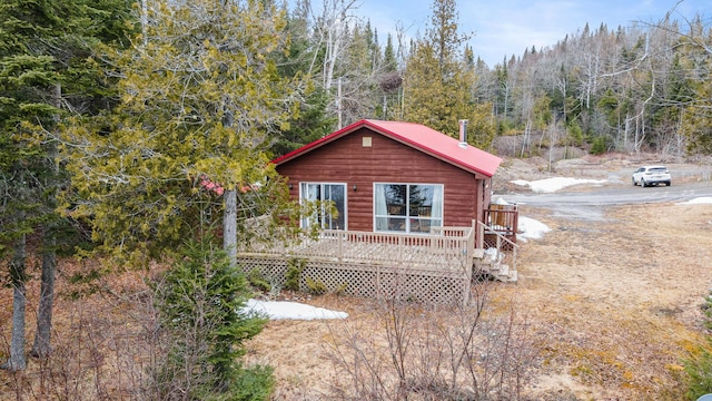 119 W Conroy Lake Rd, Monticello, ME 04760 - view of side of property with a view of trees, a wooden deck, metal roof, and faux log siding