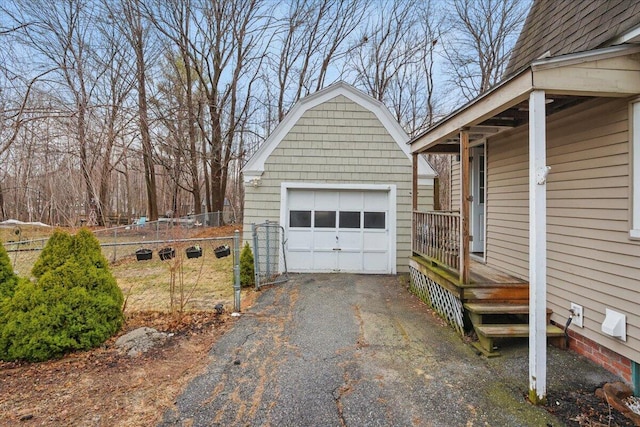 detached garage with fence and aphalt driveway