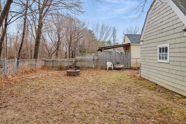 view of yard with an outdoor fire pit and fence