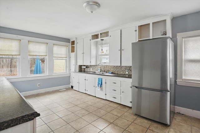 kitchen featuring white cabinetry, a sink, freestanding refrigerator, and open shelves