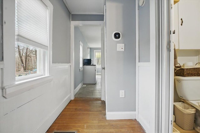 hall with light wood-style flooring and baseboards