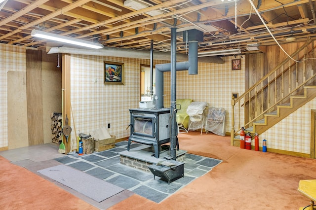 198 Hooper Rd, Shapleigh, ME 04076 - below grade area with a wood stove, stairway, and wallpapered walls