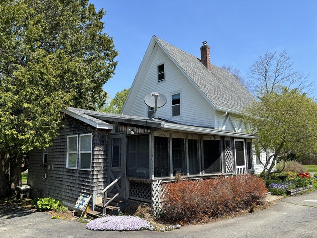 20 Westbrook St, South Thomaston, ME 04858 - view of front facade featuring a chimney, a sunroom, a shingled roof, and entry steps
