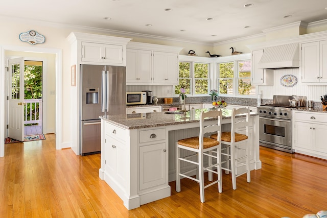 21 Bristol Dr, Rockport, ME 04856 - kitchen with stone counters, white cabinets, a center island with sink, stainless steel appliances, and premium range hood