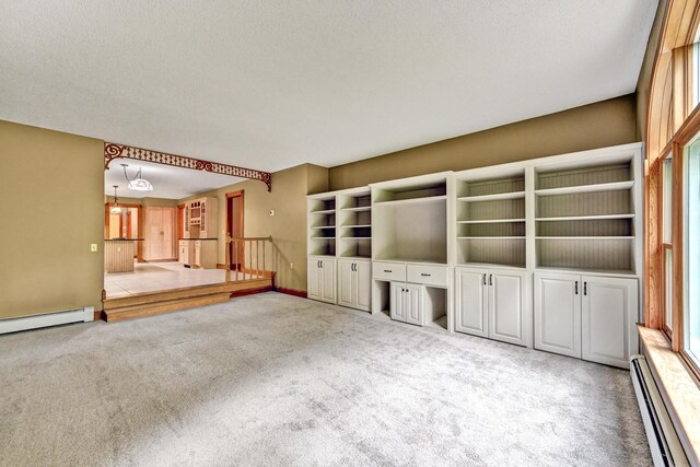 unfurnished living room with a baseboard radiator, a baseboard heating unit, carpet flooring, and a textured ceiling