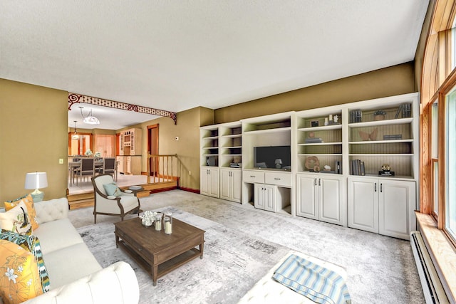 living area with baseboards, a baseboard heating unit, and light carpet