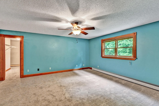 carpeted empty room with baseboards, a ceiling fan, a baseboard heating unit, and a textured ceiling