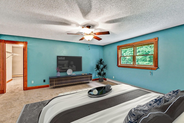 bedroom featuring baseboards, a ceiling fan, carpet, a textured ceiling, and baseboard heating