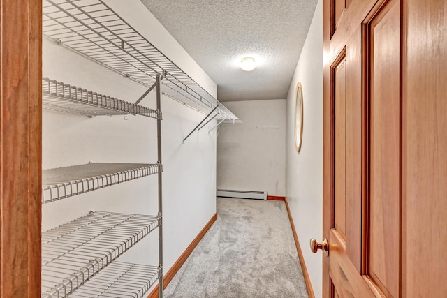 walk in closet with carpet and baseboard heating