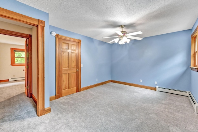 unfurnished bedroom featuring ceiling fan, carpet, a textured ceiling, baseboard heating, and baseboards