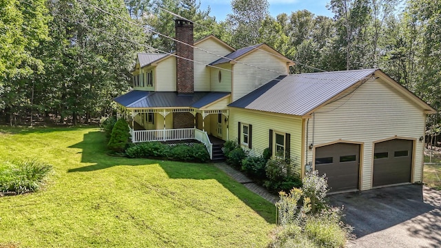 view of front of home with metal roof, a front lawn, covered porch, and aphalt driveway