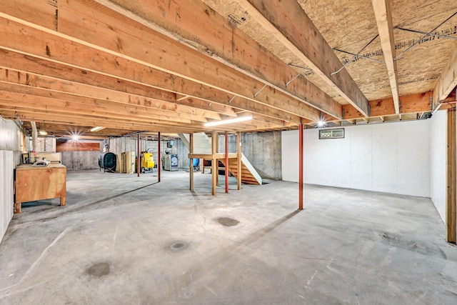 unfinished basement featuring heating fuel and stairs