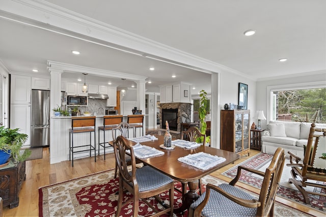 35 Barrows Rd, Boothbay Harbor, ME 04538 - dining room featuring a fireplace, light wood finished floors, ornamental molding, ornate columns, and recessed lighting