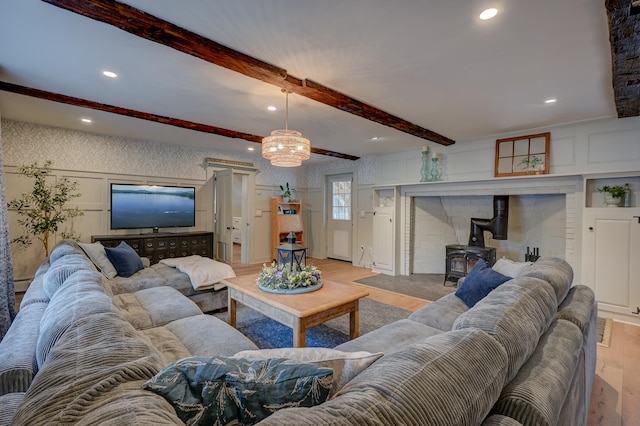 917 Main St, Fryeburg, ME 04037 - living room with wood finished floors, a wood stove, beam ceiling, a decorative wall, and recessed lighting