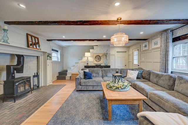 917 Main St, Fryeburg, ME 04037 - living area featuring beam ceiling, stairs, healthy amount of natural light, a chandelier, and a wood stove