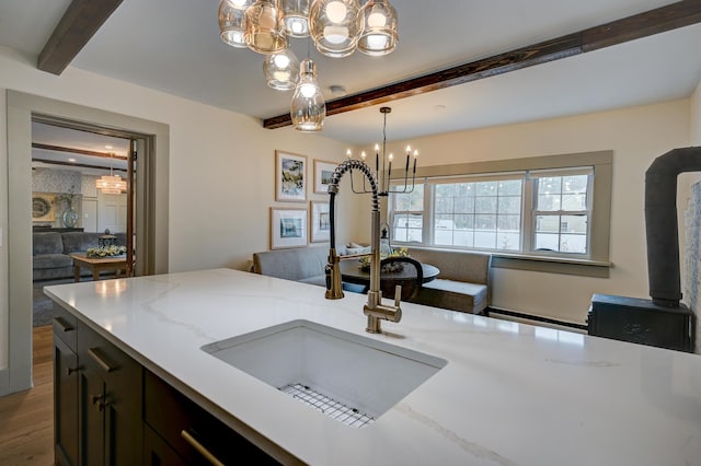 917 Main St, Fryeburg, ME 04037 - kitchen featuring a chandelier, a sink, beam ceiling, wood finished floors, and light stone counters
