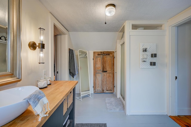 917 Main St, Fryeburg, ME 04037 - bathroom with a textured ceiling, vanity, a shower with shower door, and baseboards