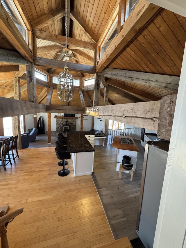 93 Goods Point Rd, Steuben, ME 04680 - interior space featuring wood ceiling, ceiling fan with notable chandelier, hardwood / wood-style flooring, a fireplace, and vaulted ceiling with beams