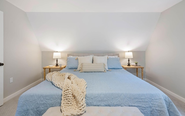 carpeted bedroom with baseboards and vaulted ceiling
