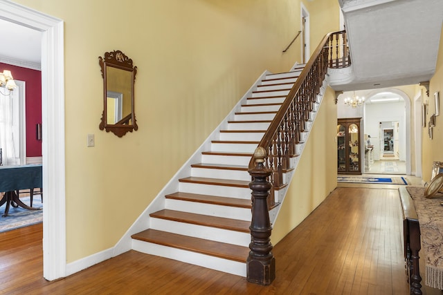 103 S St, Bath, ME 04530 - stairs featuring an inviting chandelier, a towering ceiling, hardwood / wood-style flooring, and baseboards