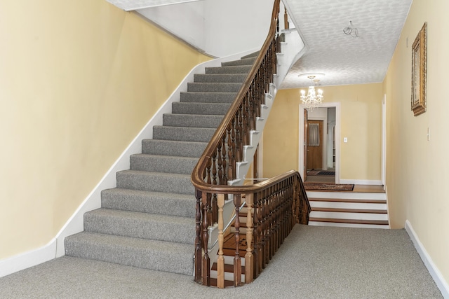 103 S St, Bath, ME 04530 - stairway with a textured ceiling, a chandelier, carpet floors, and baseboards