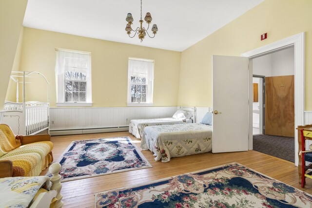 103 S St, Bath, ME 04530 - bedroom featuring a baseboard heating unit, a wainscoted wall, an inviting chandelier, and wood-type flooring