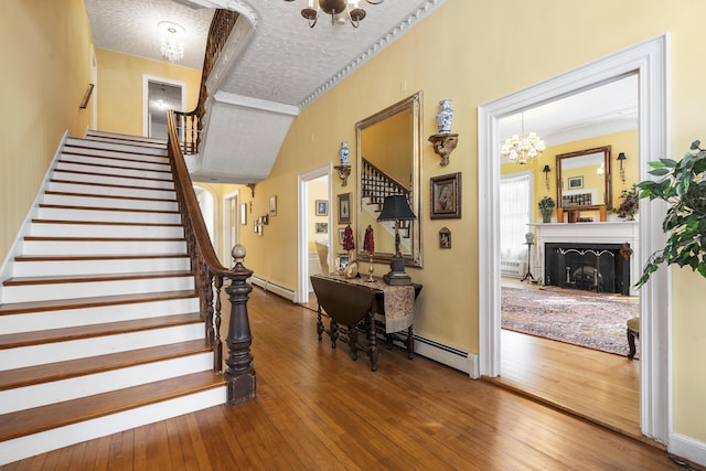 103 S St, Bath, ME 04530 - interior space featuring stairs, an inviting chandelier, hardwood / wood-style flooring, and a baseboard radiator