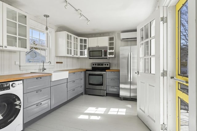 9 School St, Boothbay Harbor, ME 04538 - kitchen with washer / clothes dryer, a sink, appliances with stainless steel finishes, butcher block counters, and gray cabinets