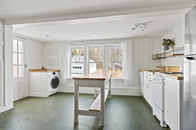 9 School St, Boothbay Harbor, ME 04538 - kitchen featuring finished concrete flooring, open shelves, washer / dryer, a sink, and white range with electric cooktop