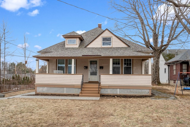 bungalow-style home featuring a shingled roof, covered porch, and a chimney
