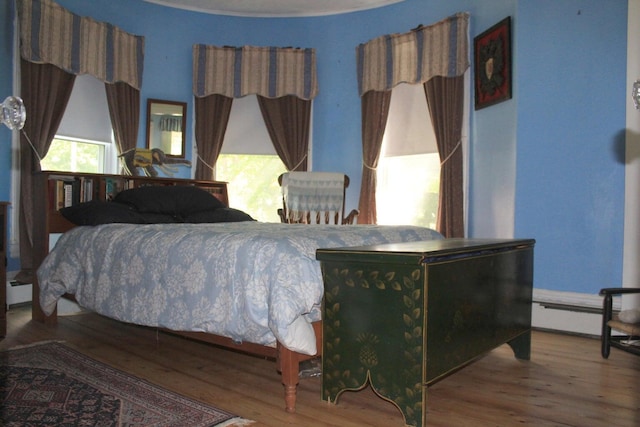 16 Pleasant St, Milo, ME 04463 - bedroom featuring a baseboard heating unit and wood finished floors