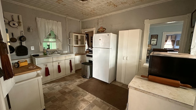 16 Pleasant St, Milo, ME 04463 - kitchen featuring crown molding, freestanding refrigerator, stone finish flooring, light countertops, and an ornate ceiling