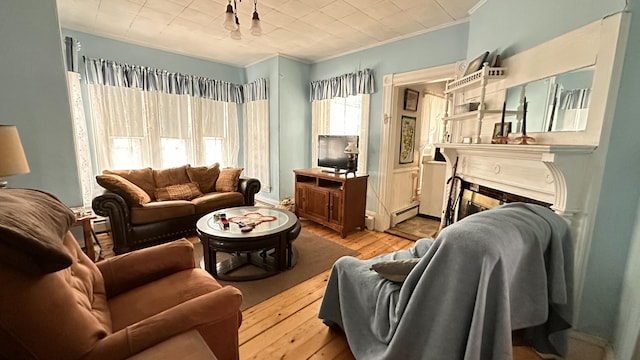 16 Pleasant St, Milo, ME 04463 - living room with a tile fireplace, baseboard heating, ornamental molding, and wood finished floors